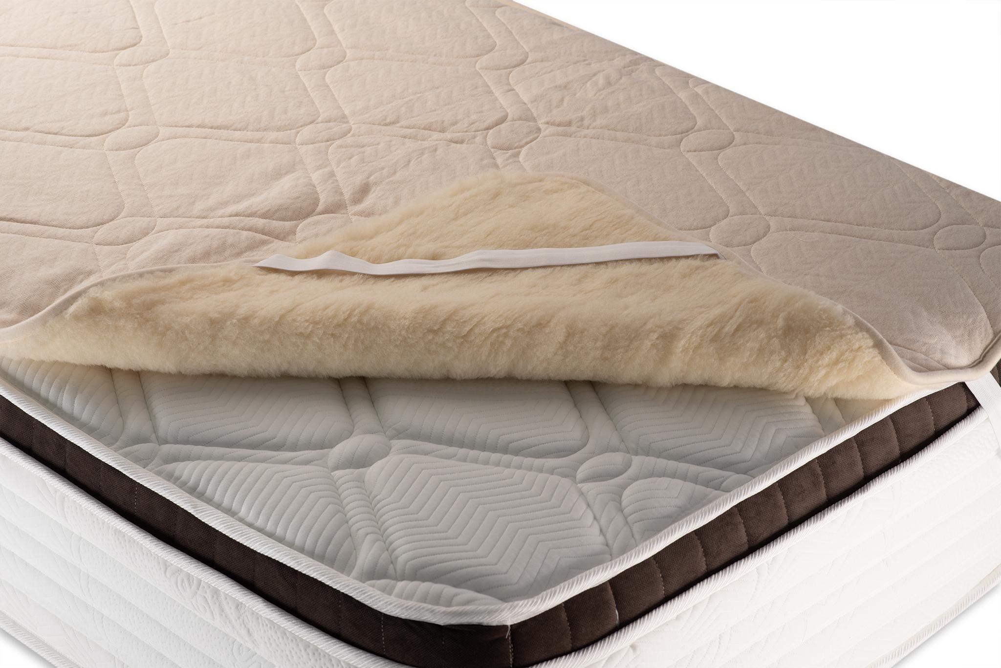 Mattress with a beige quilted hemp and wool topper on a white background. Handmade by the Woolland
