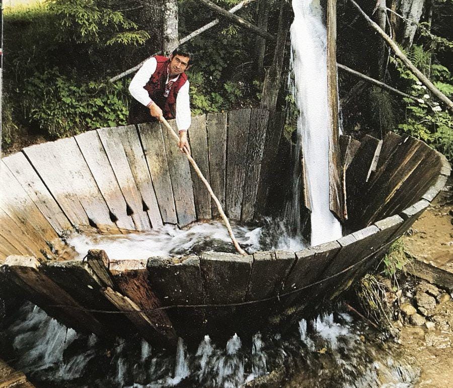 Man operating on tepavitza - a traditional Bulgarian method of washing wool wich is a wooden water wheel with water flowing.