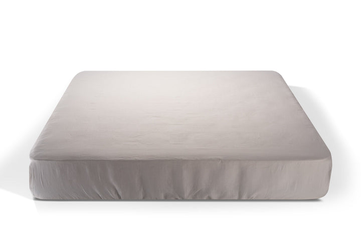 white linen fitted sheet on a white background. Handcrafted by Woolland