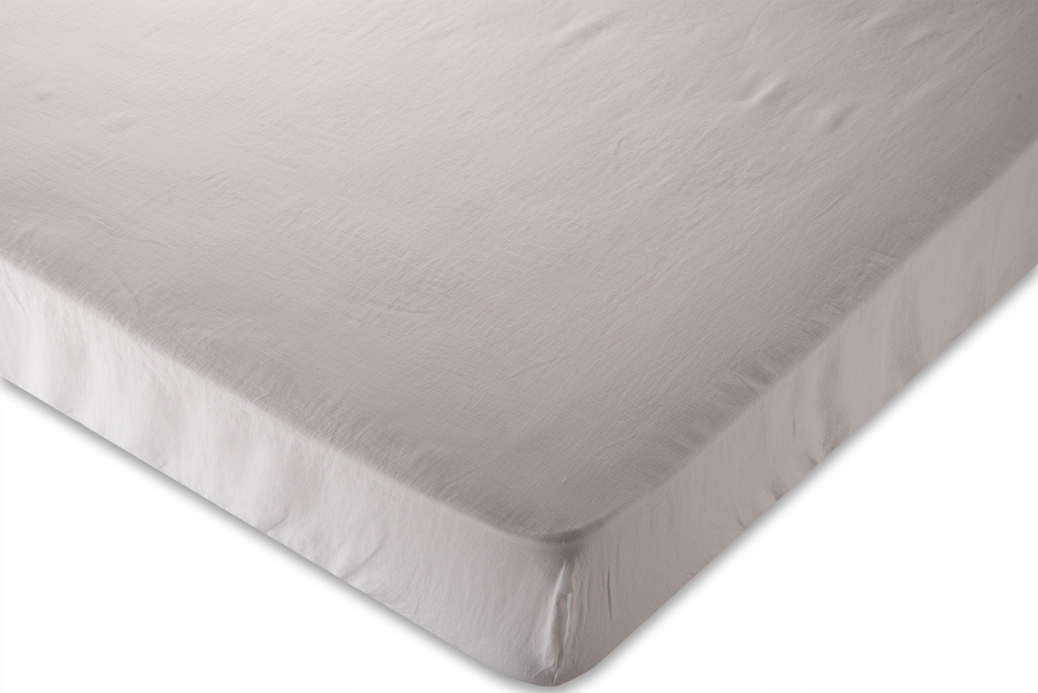corner photo of white pure linen fitted sheet on a white background. Handmade by the Woolland