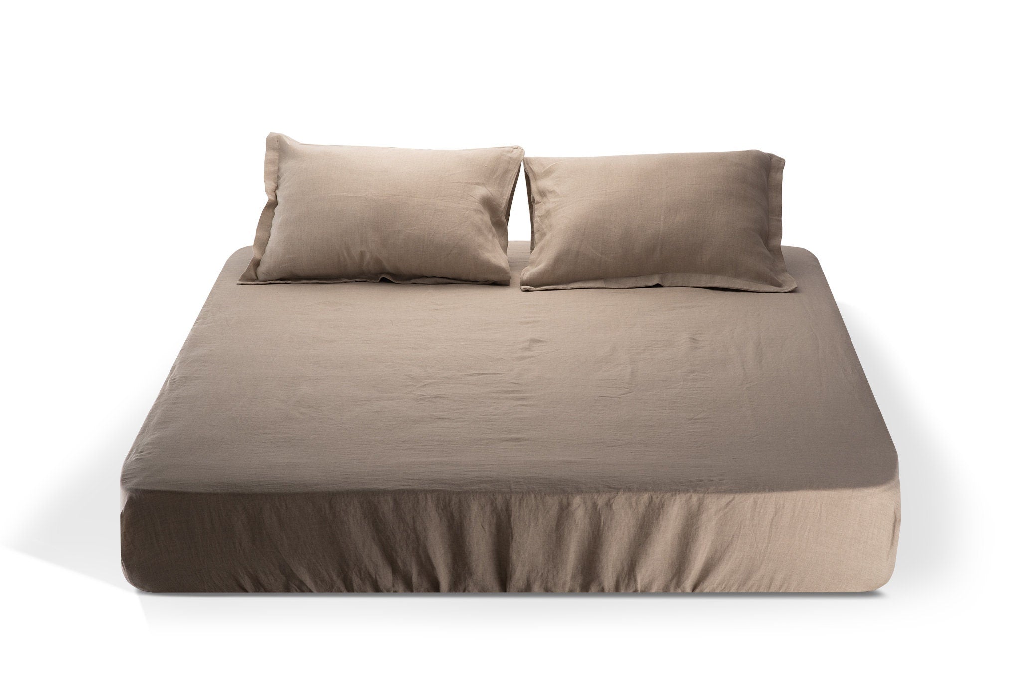 Natural color linen fitted sheet with matching pillows on a white background. Made by the Woolland