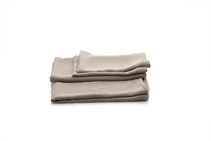 Stack of folded linen bedding set on a white background handmade by the Woolland