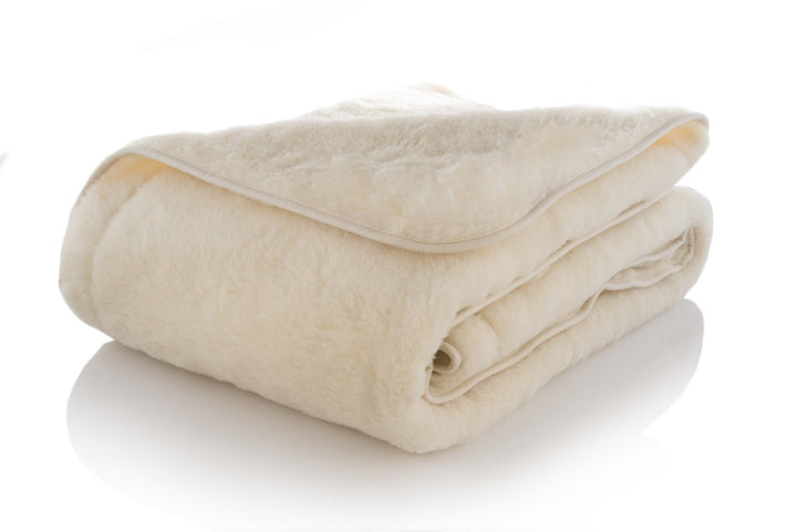 Folded merino wool blanket on a white background. Handcrafted by Woolland