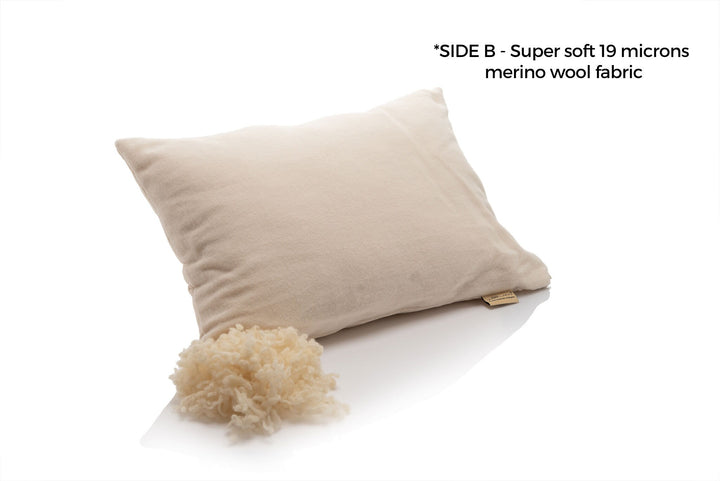 Beige pillow with fluffy merino wool on a white background, labeled 'SIDE B - Super soft 19 microns merino wool fabric'. Handcrated by Woolland