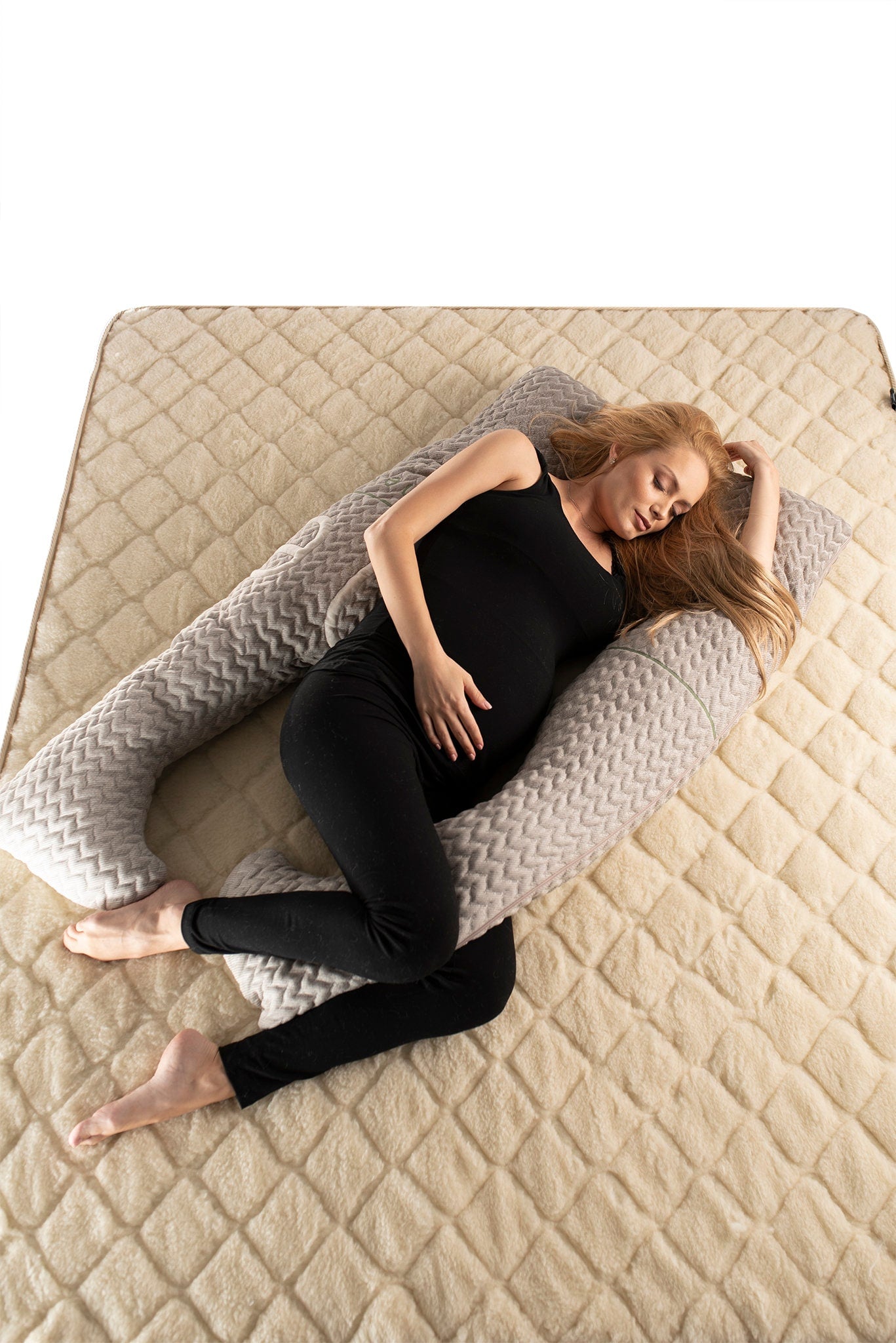 Pregnant lady laying on woolen mattress and resting with u-shaped hemp and wool pregnancy pillow