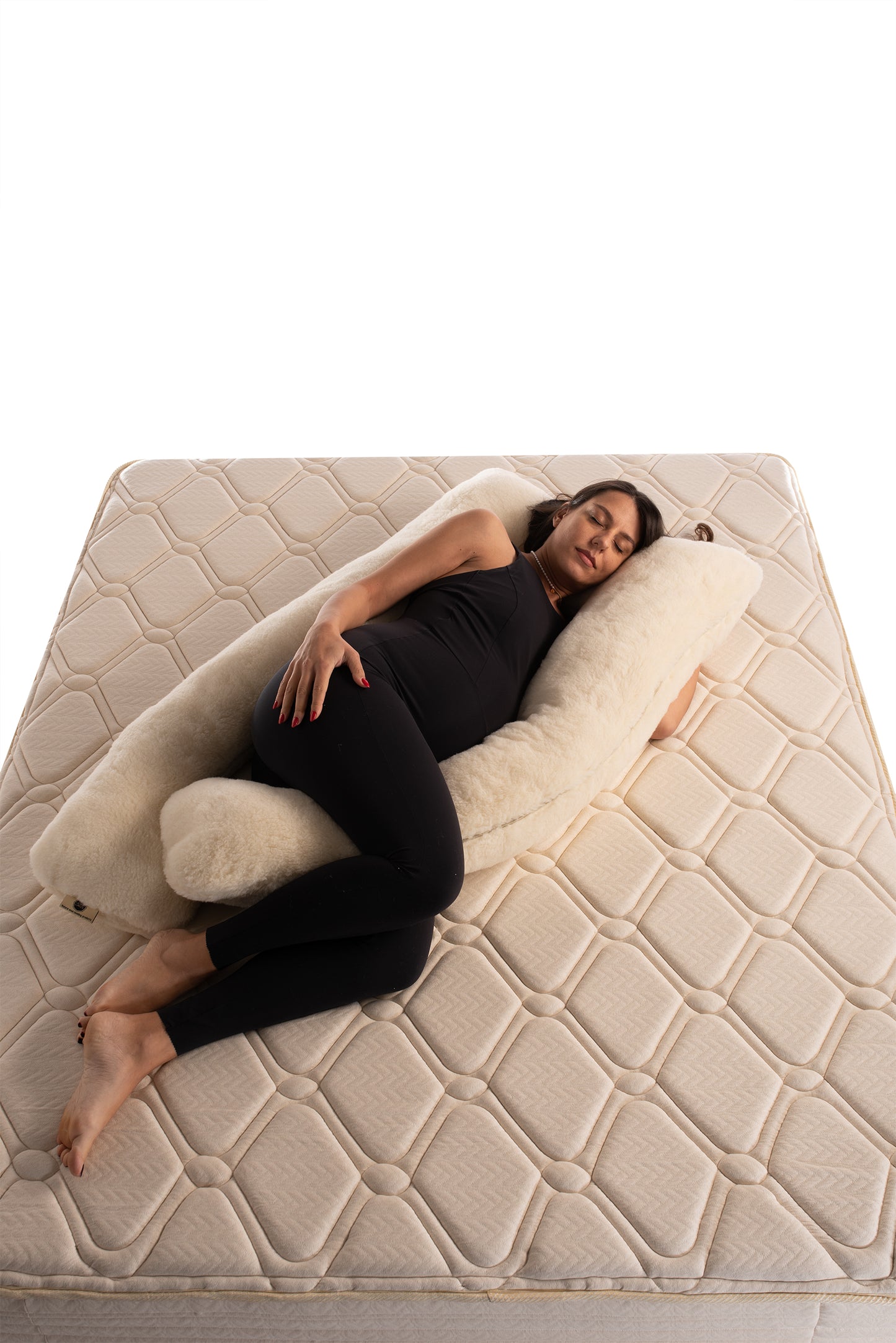 Person lying on a u-shaped merino wool maternity pillow handmade by Woolland