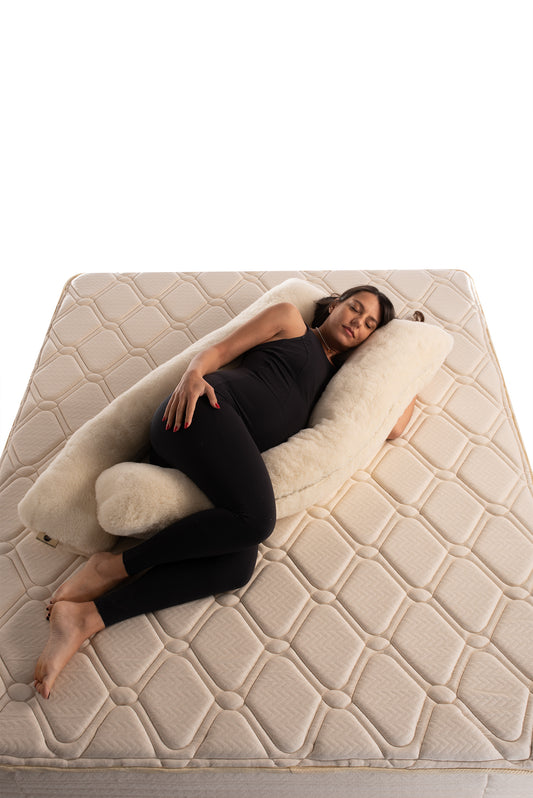 Person lying on a u-shaped merino wool maternity pillow handmade by Woolland