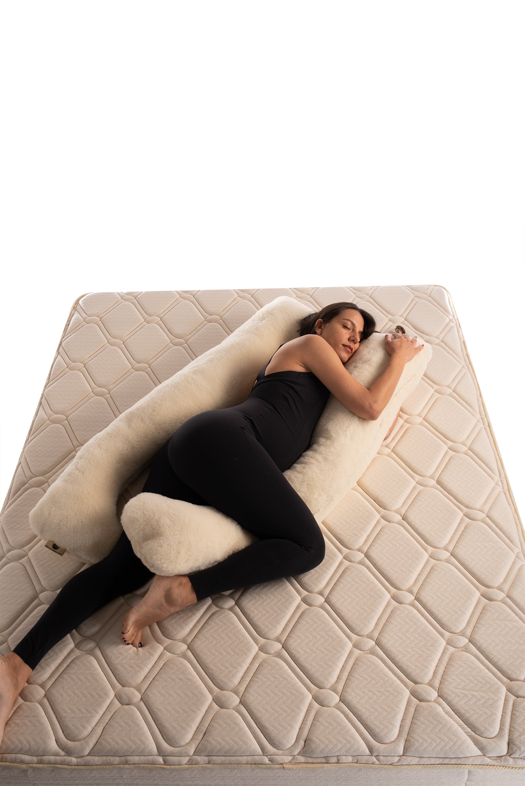 lady laying and snuggling natural merino wool pregnancy pillow handmade by the Woolland