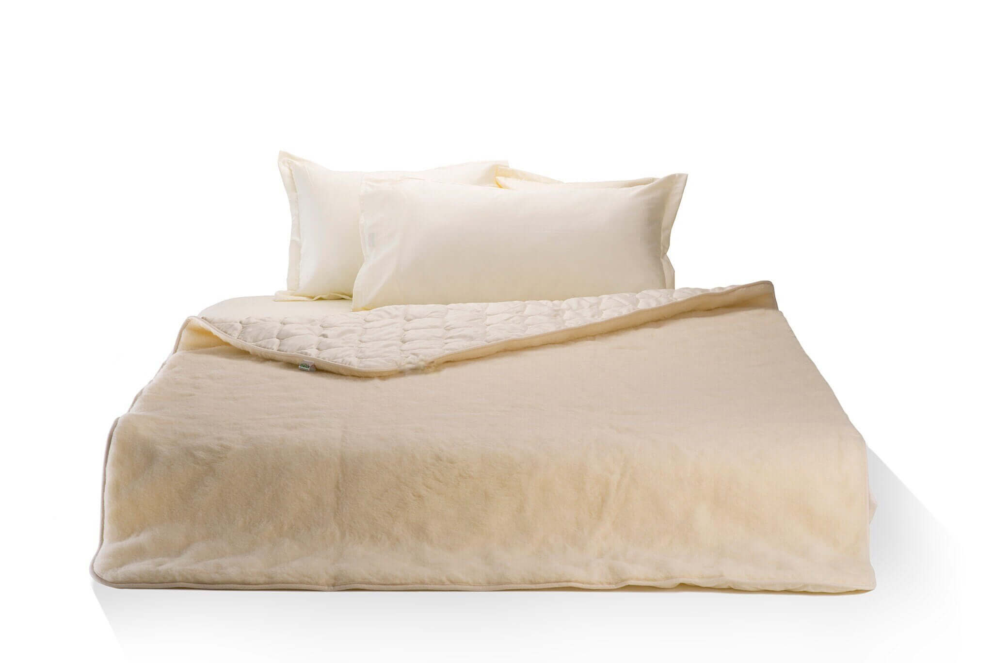 Merino wool and cotton sateen blanket on a bed . Handmade by Woolland.