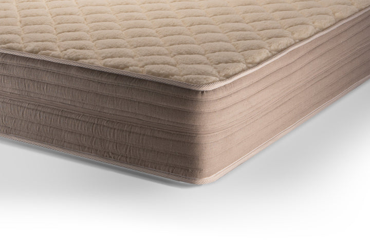 Close-up of a beige quilted mattress cover on a white background