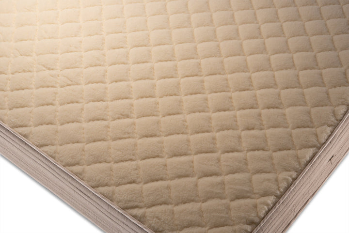 Close-up of a quilted merino wool side of mattress cover on a white background