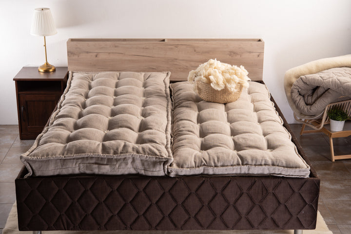 Two pieces of Natural handmade linen and wool mattresses on a bed 