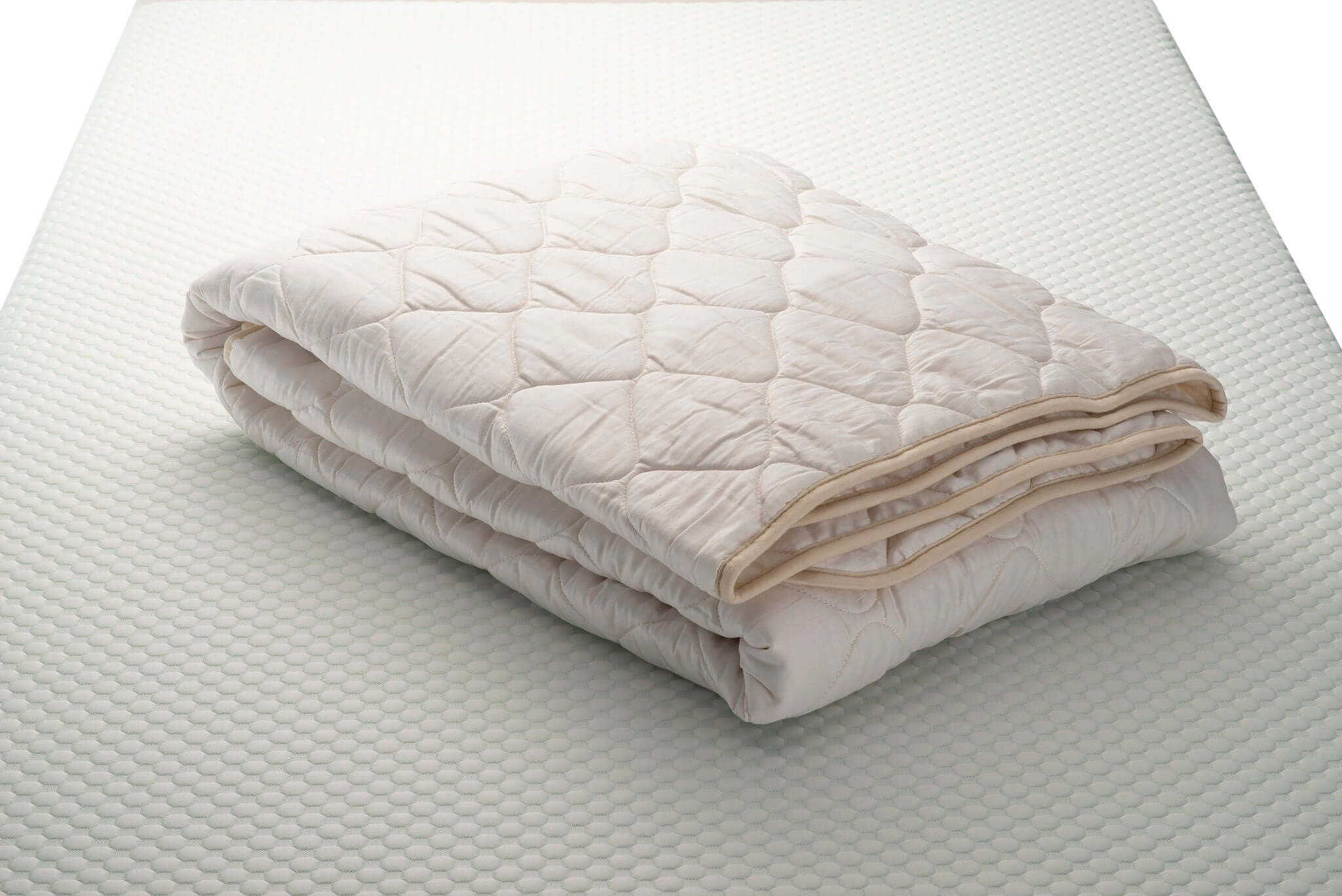 Folded wool and cotton sateen quilt. Handcrafted by Woolland